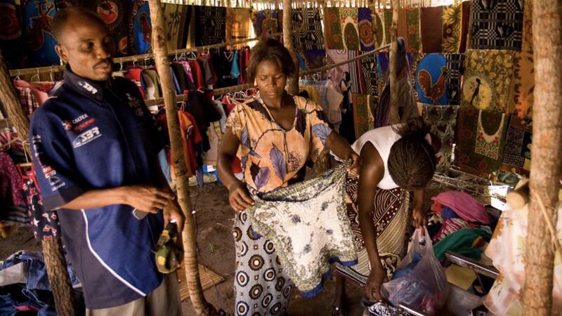Loan client talking about his business in a market outside of Chimoio.